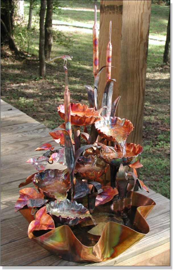 Six tiered copper waterfall with cattails.