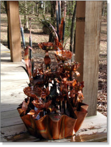 Large eight tiered copper fountain with a magnolia or irises